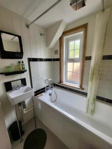uma casa de banho com uma banheira grande e um lavatório em Aviemore Rye em Rye