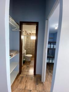 a bathroom with a toilet and a bathroom with blue walls at Residencial Gralha Azul in Florianópolis