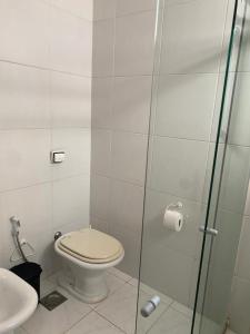 a bathroom with a toilet and a glass shower stall at Apartamento Avenida Atlântica in Rio de Janeiro