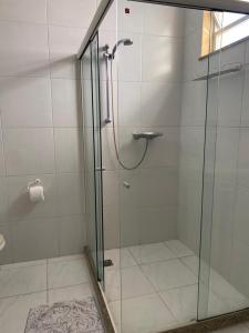 La salle de bains est pourvue d'une douche avec une porte en verre. dans l'établissement Apartamento Avenida Atlântica, à Rio de Janeiro