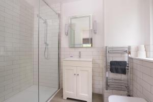 a white bathroom with a sink and a shower at Ballater Bungalow - 4 bed - Beautiful Garden in Ballater +13 photos