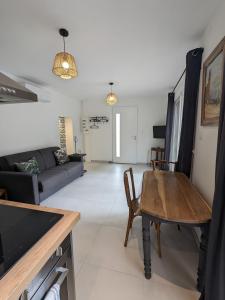 a living room with a table and a couch at L'atelier: charmante annexe indépendante in Mâcon