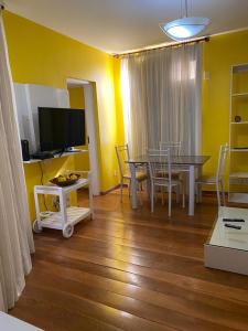 a dining room with a table and chairs and a television at Apartamento Avenida Atlântica in Rio de Janeiro