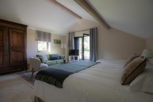 1 dormitorio con 1 cama grande y sala de estar en Domaine La Buissonnière 
