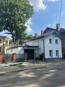 una casa blanca con una puerta y una valla en Domek Przy Termach en Jelenia Góra