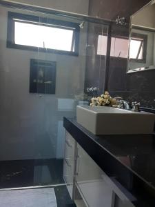 a bathroom with a sink and a mirror at Espaço Aconchego in Uberaba