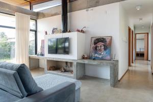 een woonkamer met een bank en een tv bij Casa próximo a Praia do Rosa EGI001 in Imbituba