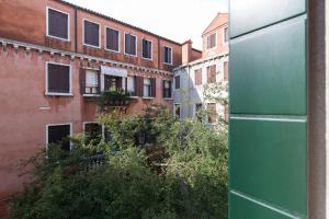 een raam met uitzicht op een appartementencomplex bij Casa Del Melograno in Venetië