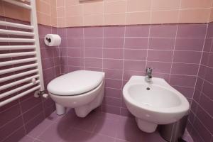 een paarse badkamer met een toilet en een wastafel bij Casa Del Melograno in Venetië