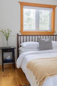 een slaapkamer met een bed en een raam bij The Doma Lodge - Cozy Muskoka Cabin in the Woods in Huntsville