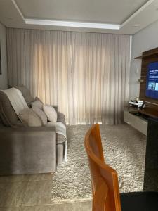 a living room with a couch and a television at Casa completa e confortável in Leopoldina