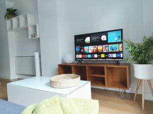 una sala de estar con TV de pantalla plana en un armario en SUITE APT 80m FROM BEACH FreeParking 500MbWifi, en Las Palmas de Gran Canaria