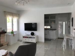 Il comprend un salon blanc avec une télévision et une cuisine. dans l'établissement Casa Alta - villa med privat svømmebasseng, à Ciudad Quesada