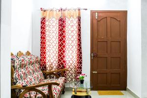 a living room with a chair and a door at Tranquil Meadows Hues in Kattappana
