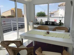 Cette chambre dispose d'un balcon avec une table et des chaises blanches. dans l'établissement Casa Alta - villa med privat svømmebasseng, à Ciudad Quesada