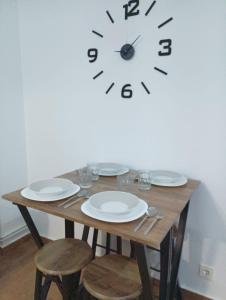 una mesa con platos y un reloj en la pared en Apto céntrico CASA CONCHA VUT 47-127, en Valladolid