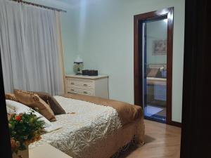 um quarto com uma cama, uma cómoda e um espelho em Espaço Aconchego em Uberaba