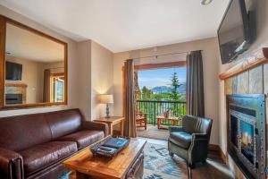 a living room with a couch and a table and a tv at Mountain Lodge at Telluride in Telluride