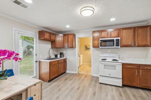 a kitchen with wooden cabinets and a white stove top oven at Elm Two Bedroom House in Historic Loveland in Loveland