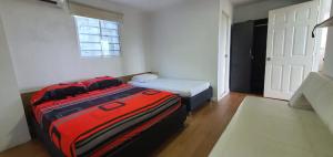 Habitación con cama y maleta roja en Cabaña villa kary en Barranquilla