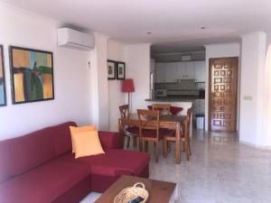 a living room with a red couch and a table at Paraíso in Cumbre del Sol