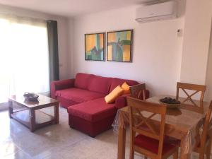 a living room with a red couch and a table at Paraíso in Cumbre del Sol