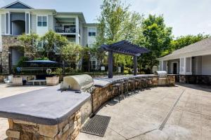a patio with a stone wall and a grill at Lake Norman Royal Retreat in Mooresville