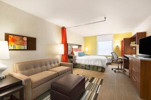 um quarto de hotel com uma cama e um sofá em Home2 Suites by Hilton Farmington/Bloomfield em Farmington