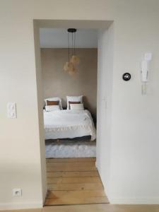 a bedroom with a bed with white sheets and pillows at Au pied du mur in Huy