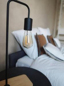 a lamp on a table next to a bed at Au pied du mur in Huy