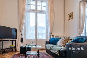 a living room with a couch and a tv at "Les Effrontés" Louis Blanc Charming Apartment in Limoges