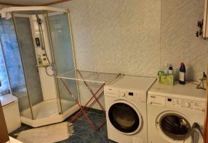 a laundry room with a washing machine and a shower at Grøtfjord in Tromsø
