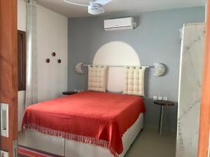 a bedroom with a red bed with a red blanket at Villa Marina in Arraial d'Ajuda +53 photos