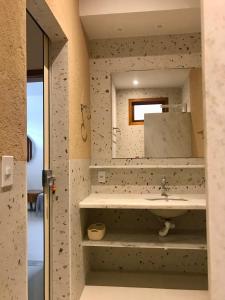 a bathroom with a sink and a mirror at Villa Marina in Arraial d'Ajuda