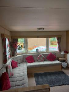 タターズホールにあるTattershall Lakes Howell Holiday Homeのリビングルーム(赤い枕と白いソファ付)