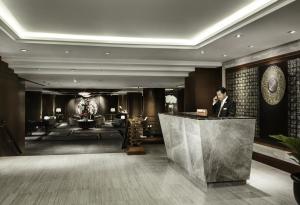 ein Mann steht an einem Tresen in einer Hotellobby in der Unterkunft Banyan Tree Bangkok in Bangkok + 37 Fotos