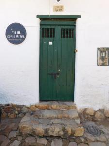 una puerta verde en el lateral de un edificio blanco en Casa Hotel Paraíso Bella Villa, en Villa de Leyva