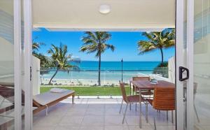 a dining room with a view of the beach at Fairshore 28 Beachfront Escape in Noosa Heads +4 photos