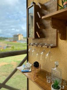 a rack of wine glasses on a wall with a window at Apbananeiras - Condomínio Sonhos da Serra in Bananeiras
