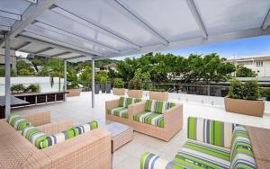 努沙岬的住宿－Fairshore Apartment 28, Noosa Heads，屋顶上带沙发和椅子的庭院