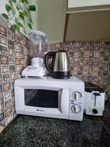a blender sitting on top of a white microwave at Three Bed Attached Bath Netflix Wifi Smart TV Parking WFH Desk in Islamabad