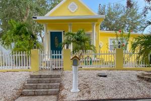 a yellow house with a white fence at Baycation on Arch in Tampa