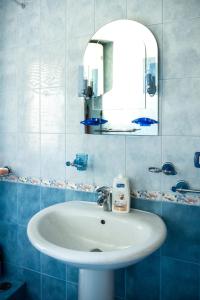 a bathroom with a white sink and a mirror at City Center Two Private Bedrooms near Scanderbeg Square on Shared Apartment in Tirana