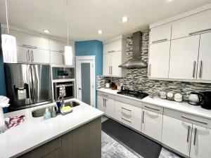 - une cuisine avec des placards blancs et un mur en pierre dans l'établissement AB5bed Spacious 5BR Home garage parking/sleeps16/Wifi, à Edmonton