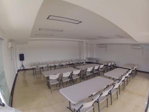 an empty room with tables and chairs and a podium at Hotel Chicala salgar in Puerto Salgar