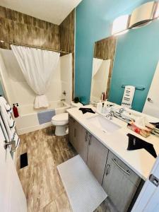 La salle de bains est pourvue d'un lavabo, de toilettes et d'une baignoire. dans l'établissement AB5bed Spacious 5BR Home garage parking/sleeps16/Wifi, à Edmonton