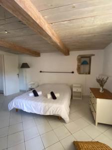 een slaapkamer met een wit bed en een houten plafond bij La casa Bea in Cotignac