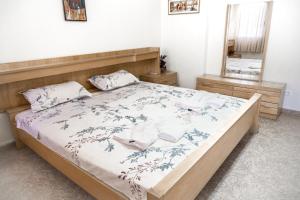 1 dormitorio con 1 cama con cabecero de madera y espejo en City Center Two Private Bedrooms near Scanderbeg Square on Shared Apartment en Tirana
