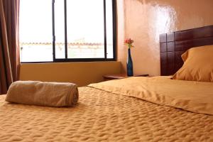 a bedroom with a large bed with a large window at Hotel Norte in Cuenca