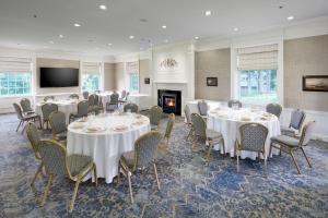 a conference room with tables and chairs and a fireplace at Andover Inn in Andover
